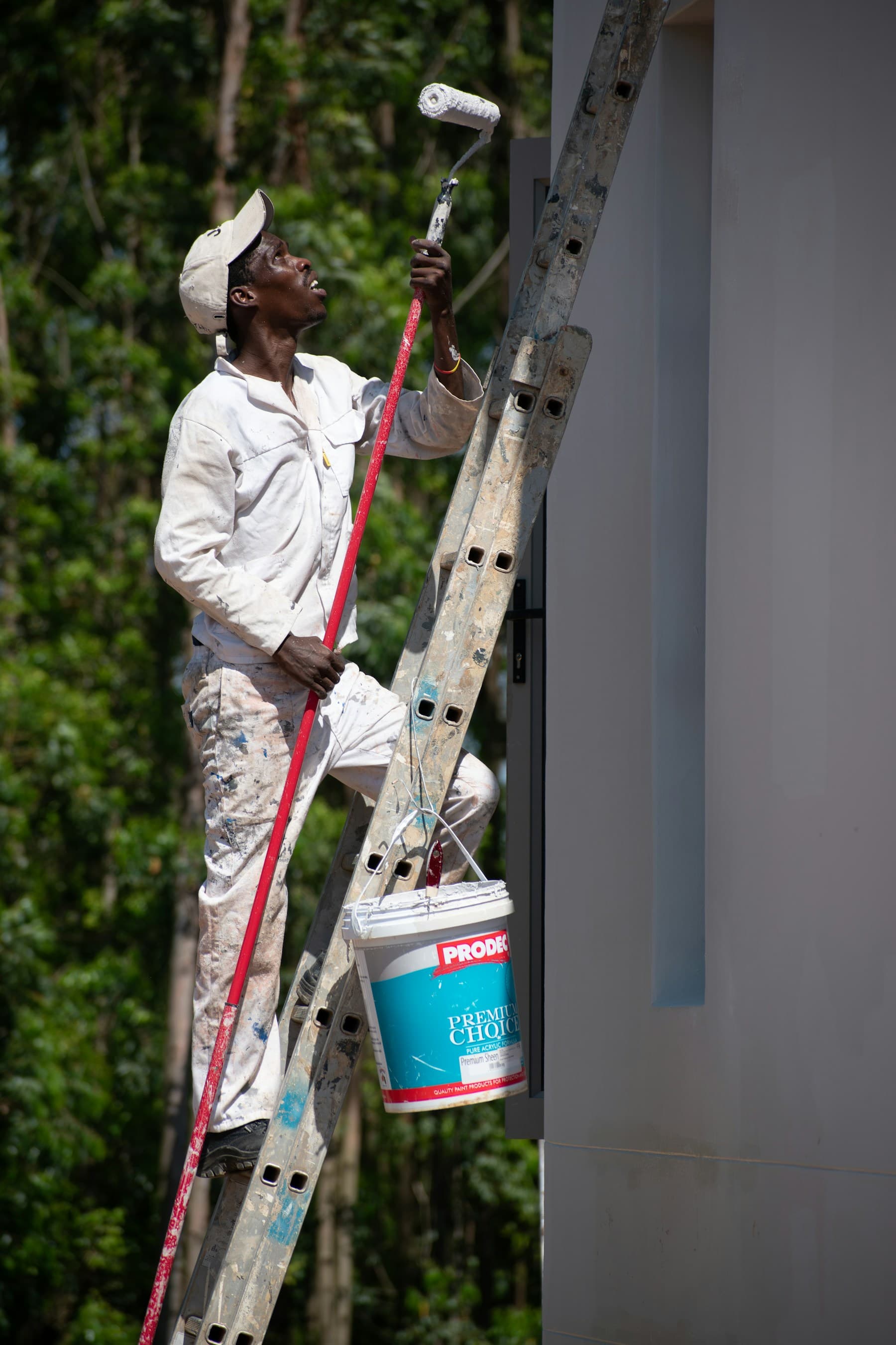 Ottawa exterior painter applying fresh paint from a ladder